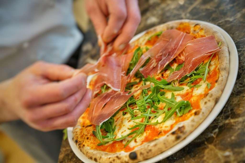 Vila Vita Rosenpark Marburg Eksteriør bilde Pizza being topped with prosciutto